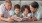 grandparents read to their grandchildren on living room floor